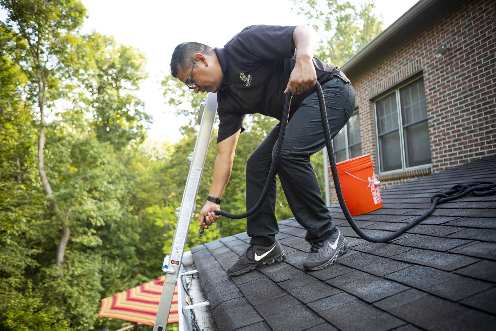 Technician clearing guttering from the roof edge